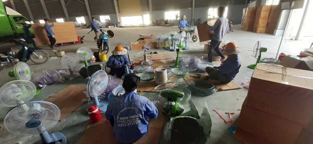 Workers are assembling electric fans and bringing them into the field